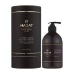 Dark brown Hadat cosmetics Hydro Liquid Silk Treatment bottle with matching cylindrical box and gold trim; pump bottle and label visible (500 ml).