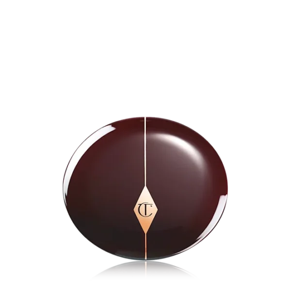 Glossy dark chocolate sphere with a gold diamond emblem at the center and a vertical seam, reflected on a surface.