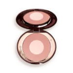 Open compact containing pink-toned face powder with a pale center, mirror reflecting above it