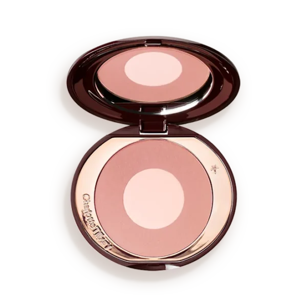 Open compact containing pink-toned face powder with a pale center, mirror reflecting above it