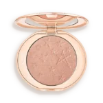 Round rose-gold makeup compact opened to reveal a shimmery peach highlighter with star embossing on the powder surface.