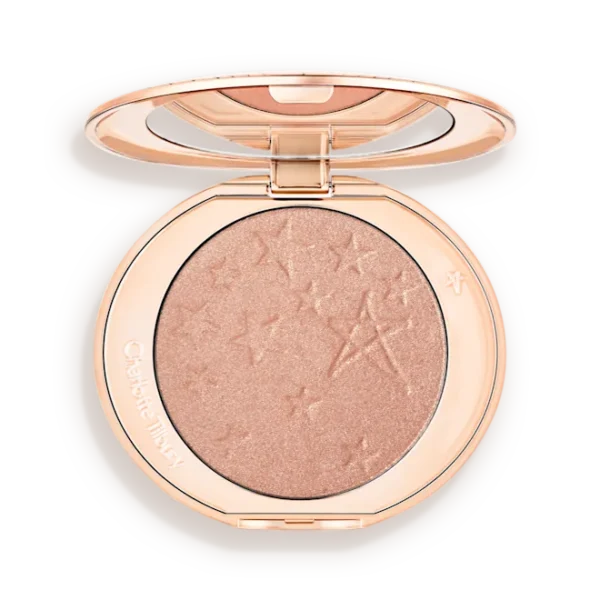 Round rose-gold makeup compact opened to reveal a shimmery peach highlighter with star embossing on the powder surface.