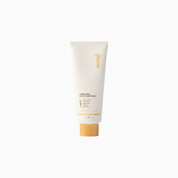 Cream cosmetic tube with orange cap, standing upright, beige packaging and gold text logo visible on the side (No. 5-1-? styling cream)