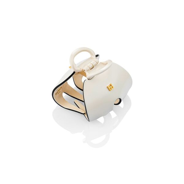 Ivory Balmain handbag with a circular top handle and gold logo on a white background.