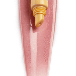 banana_5_9х16 - shopcosmoprof.com Close-up of a yellow banana lip balm tube with SPF 20 resting on a pink glittery nail surface.