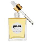 Glass bottle of GISOU honey-infused hair oil with a white dropper and gold cap, against a white background, showing pale yellow oil inside (20 ml).