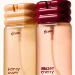 images - shopcosmoprof.com Two Gisou hair and body mist bottles, Honey dewy (left) and Glazed cherry (right), with ribbed caps and pale pink-tinted liquids.