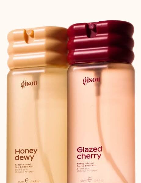 Two Gisou hair and body mist bottles, Honey dewy (left) and Glazed cherry (right), with ribbed caps and pale pink-tinted liquids.