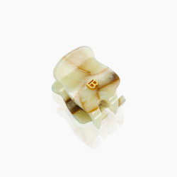 Cream-colored, shell-shaped ring with a small gold 'B' centerpiece.