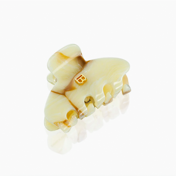 Marbled beige-yellow hair clip with interlocking teeth and a small gold 'B' logo
