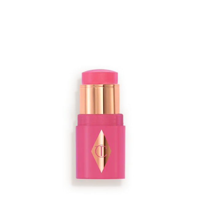 MINI_UNREAL_BLUSH_HEALTHY_GLOW_STICK_-_OPEN_-_PINKY_GLOWpng - shopcosmoprof.com Pink lipstick in a bright pink case with gold inner tubes and a diamond logo on the front, ready to apply