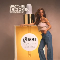 NEW_HIHO_PDP1jpg - shopcosmoprof.com Model leaning on a giant Gisou honey-infused hair oil bottle, promoting glossy shine and frizz control in an ad image.