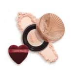 Charlotte Tilbury powder compact with pink powder and a heart-shaped burgundy applicator sponge.
