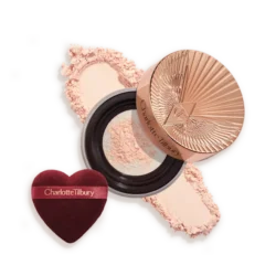 Charlotte Tilbury powder compact with pink powder and a heart-shaped burgundy applicator sponge.