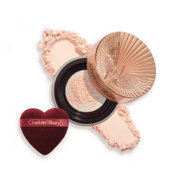 Charlotte Tilbury powder compact with pink powder and a heart-shaped burgundy applicator sponge.