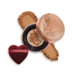 Charlotte Tilbury compact powder with rose-gold lid, pressed powder, and heart-shaped applicator puff