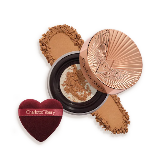 OPEN-PACKSHOT-TRANSLUCENT-TAN-DEEP-SWATCH__1_png - shopcosmoprof.com Charlotte Tilbury compact powder with rose-gold lid, pressed powder, and heart-shaped applicator puff