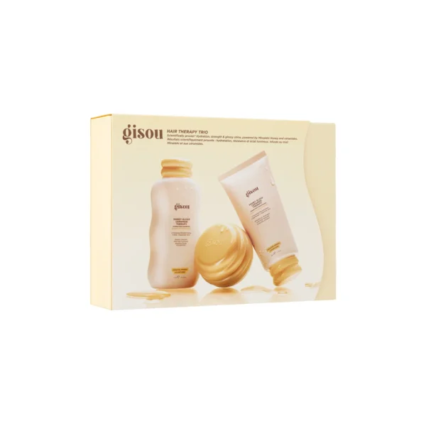 Boxed Gisou Hair Therapy Trio set featuring a bottle, a tube, and a jar in soft beige tones with gold lids and honey accents.