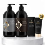 Set of black Hadat shampoo, conditioner bottles and hand cream tubes on a marble pedestal, with a small gift badge.