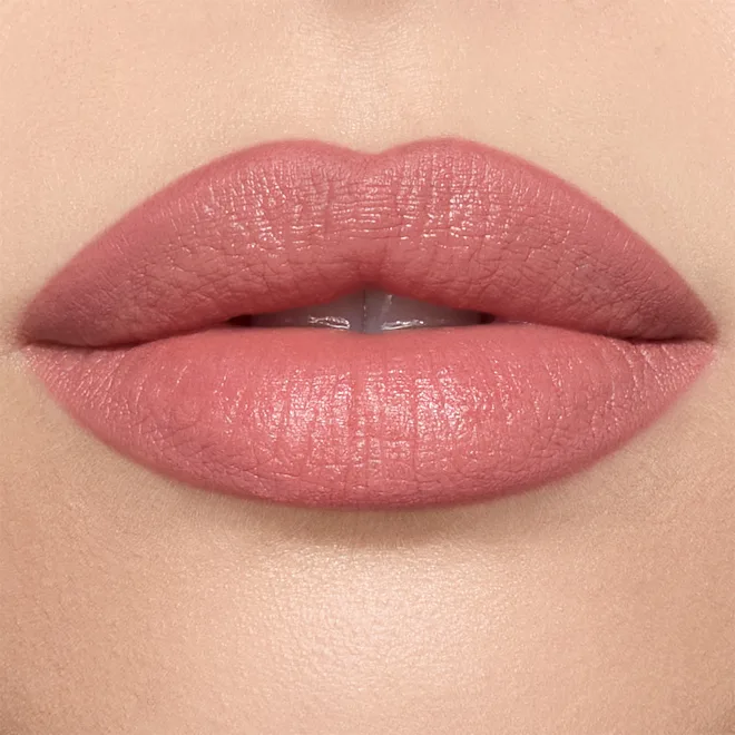 Close-up of lips wearing pink-nude lipstick, slightly parted.