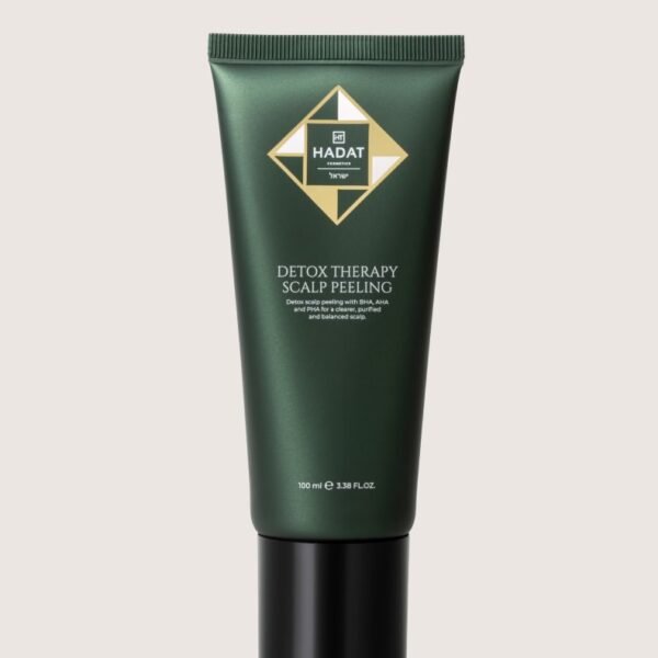 Green HADAT Detox Therapy Scalp Peeling tube with black cap standing upright on a light beige background, product shot for cosmetics.