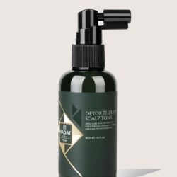 Dark green spray bottle labeled Detox Therapy Scalp Tonic with black spray nozzle.