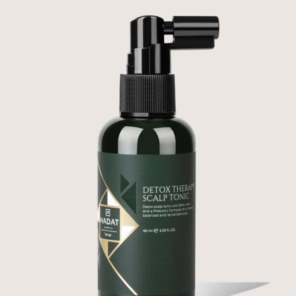 Dark green spray bottle labeled Detox Therapy Scalp Tonic with black spray nozzle.