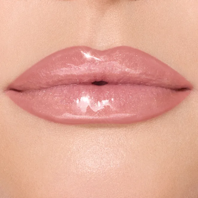 Close-up of glossy pink lips with a shiny highlight and smooth skin around.