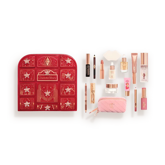 Open makeup advent calendar with a red drawer box on the left and assorted beauty products on the right on a light tray.