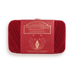 Red makeup brush set in a white tray with a red Charlotte Tilbury box labeled 'Hollywood Mini Brush Set' in the center.