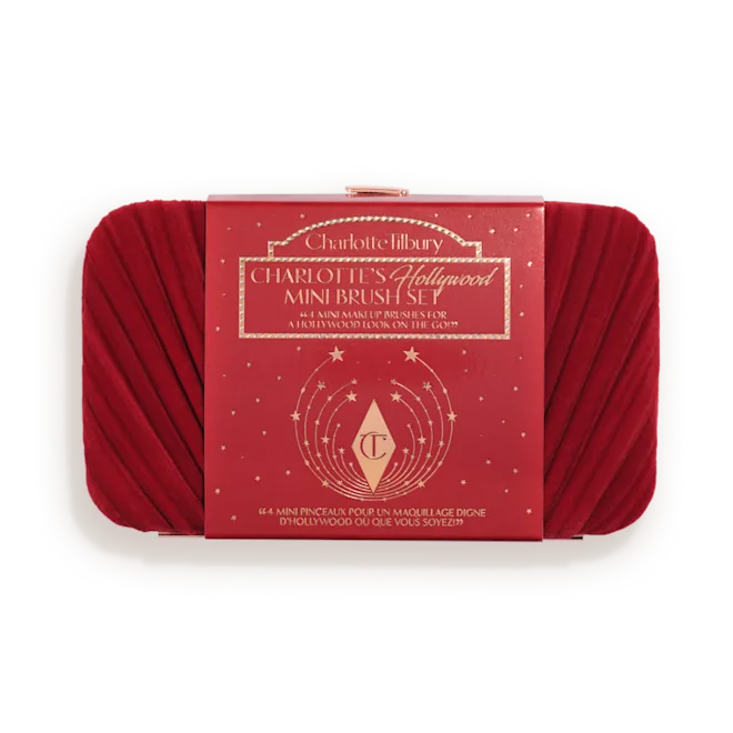 Packshot_of_Box__CHARLOTTE-S_HOLLYWOOD_MINI_BRUSH_SETpng - shopcosmoprof.com Red makeup brush set in a white tray with a red Charlotte Tilbury box labeled 'Hollywood Mini Brush Set' in the center.