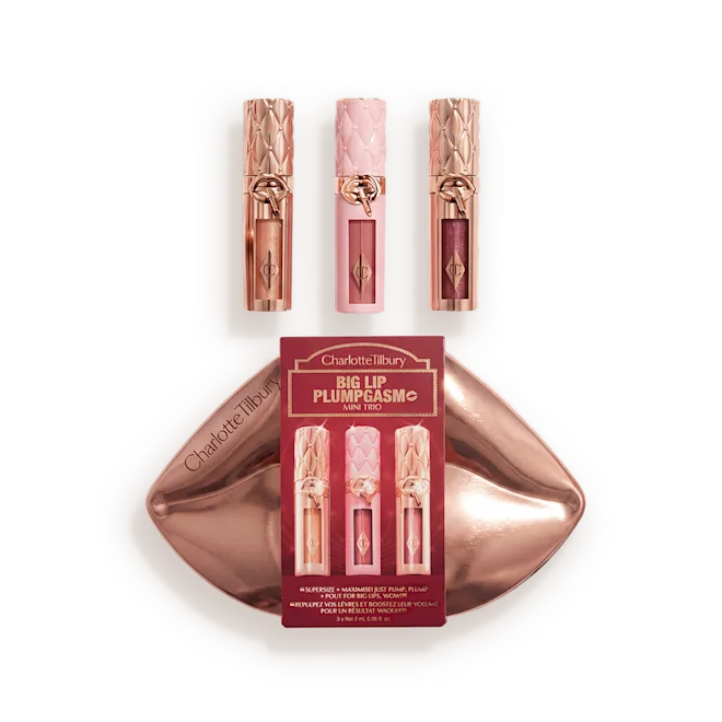 Packshot_with_Products__UNREAL_LIPS_JUICYLICIOUS_MINI_TRIO_-_XMAS_28png - shopcosmoprof.com Charlotte Tilbury Big Lip Plump & Mini Trio lip kit with three pink-rose lipsticks in rose-gold tubes on a metallic tray
