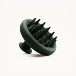 Abstract dark-green sculpture with curved, tentacle-like spikes set against a light background.